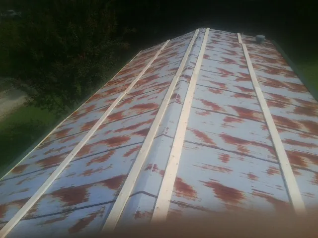Rusted metal roof panels with new wood purlins before replacement — Storm Damage Roof Repair in Lucas by Roofing Brothers