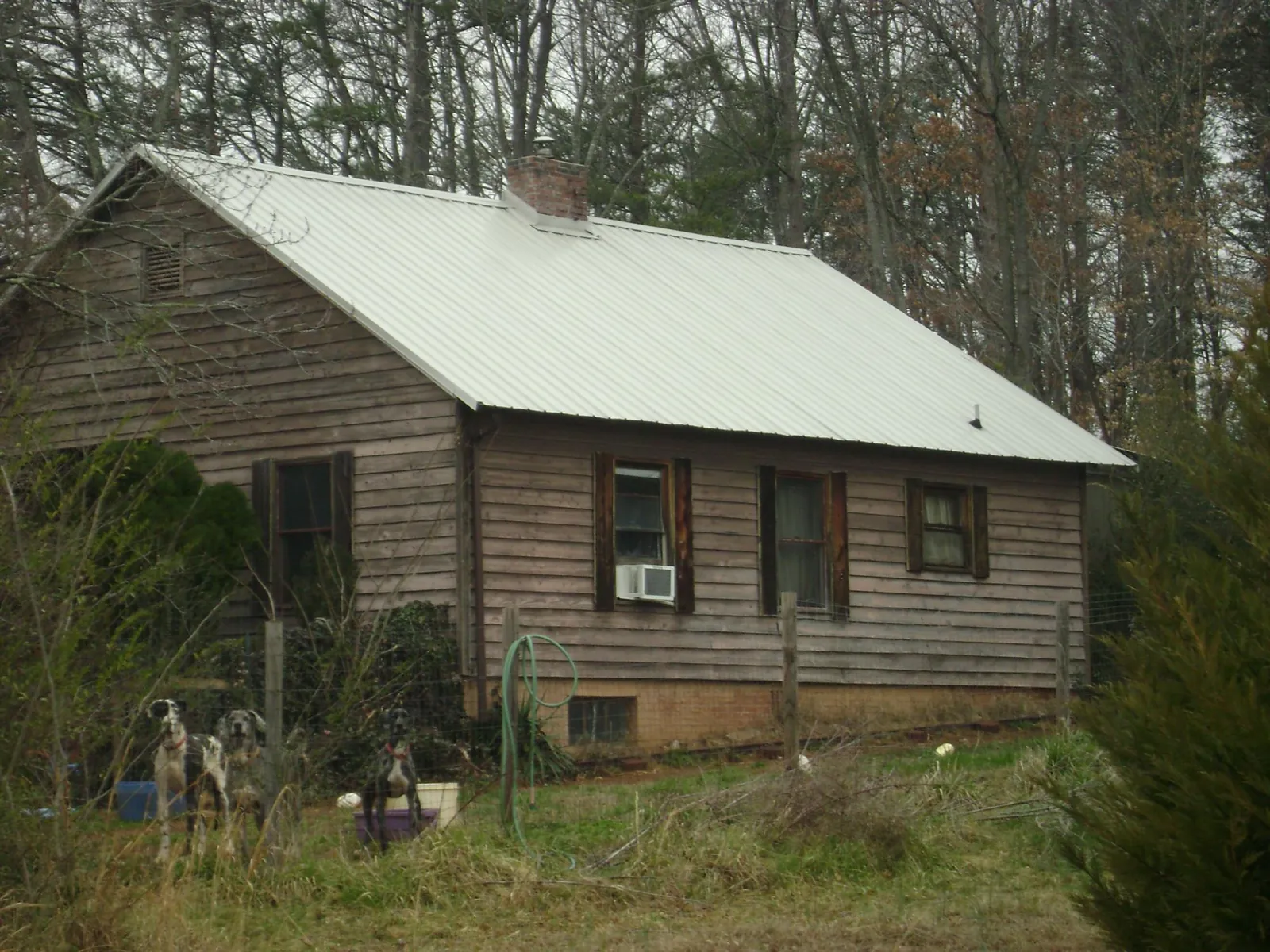 White metal roof on an old wood sided farmhouse, from a Metal Roof Installation job in Lucas